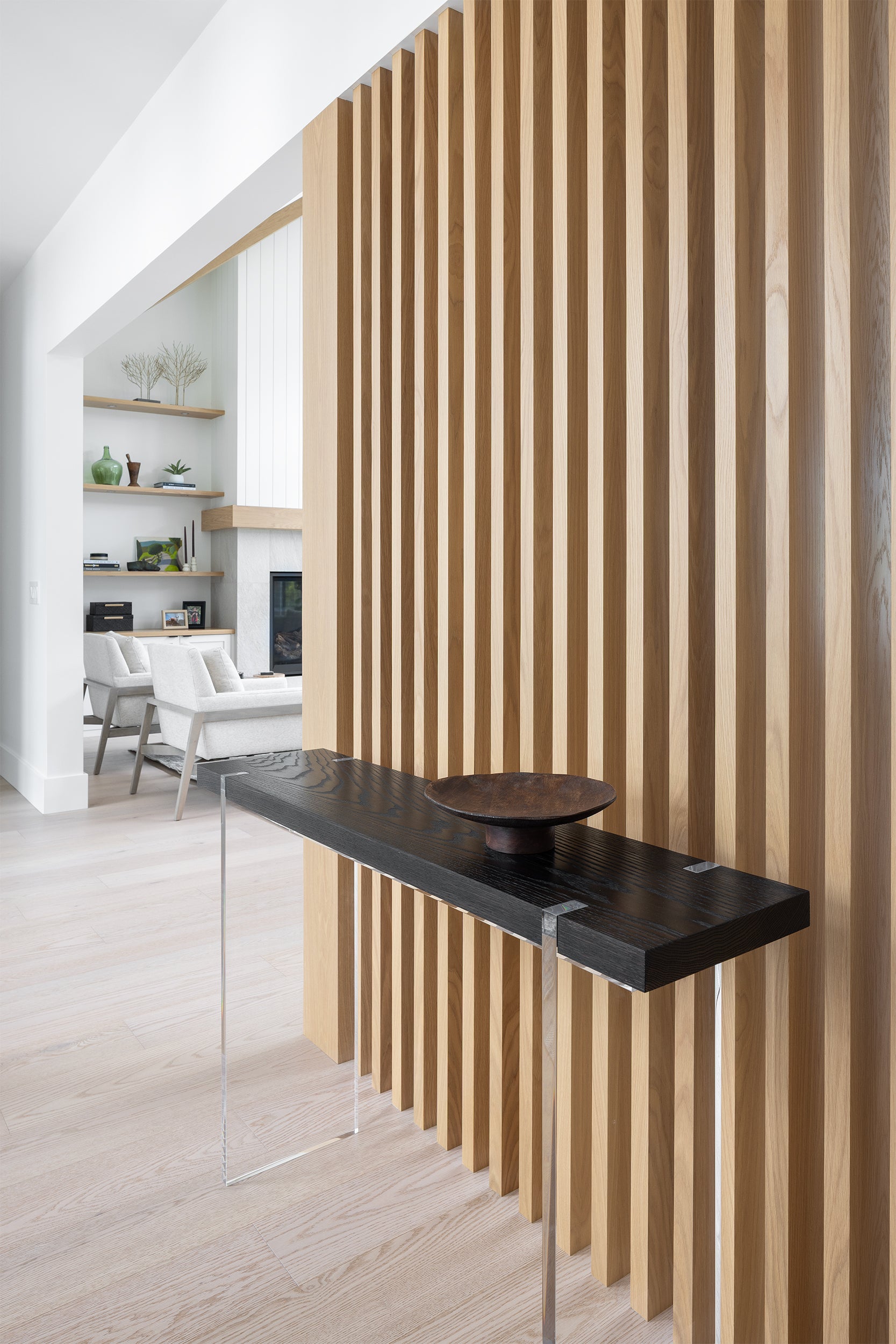 Modern interior design with a slatted wooden wall and black console table.