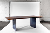 Ban Dining Table with Black Walnut Tabletop and Curved Steel Legs in Studio Photobooth Setting